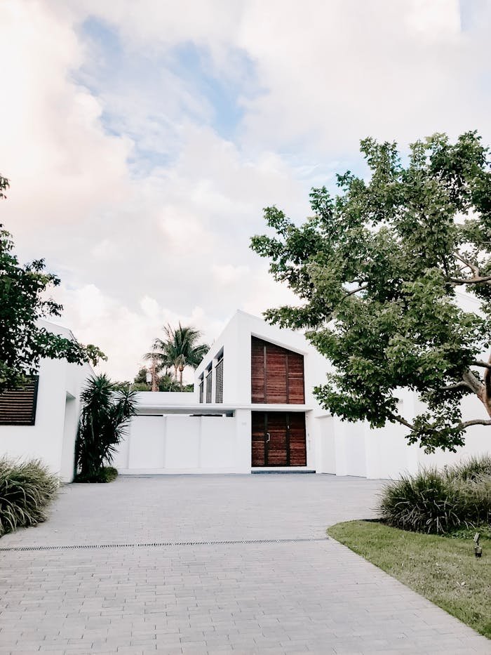 who-we-are Contemporary minimalist home exterior with lush landscaping and open driveway.